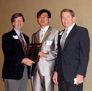 NPRE Department Head James F. Stubbins, left, and Prof. Barclay G. Jones, right, present PhD student Hyun-Jong Joe with the inaugural Jones Fellowship in NPRE.