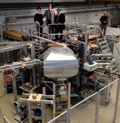 NPRE Profs. Davide Curreli, David Ruzic, and Jean Paul Allain stand atop the new HIDRA facility that the Max Planck Institute for Plasma Physics is gifting to the University of Illinois.