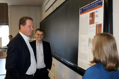 Ed McVey of Exelon Corp. discusses a research poster with NPRE student Becky Herr during a recent event. NPRE Associate Prof. Tomasz Kozlowski observes.