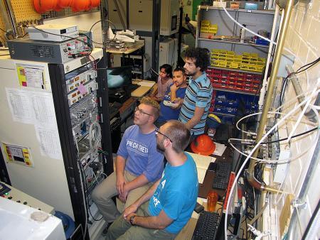 CPMI researchers run tests to shape plasma held within the HIDRA plasma/fusion device. In the background, from left to right, are Materials Science and Engineering undergraduate Sri Sowmya Panuganti, Research Assistant Prof. Daniel Andruzcyk, and NPRE graduate student Rabel Rizkallah. In the foreground, from left, are Engineering Physics undergrad Nathan Bartlett and NPRE graduate student Matthew Parsons.