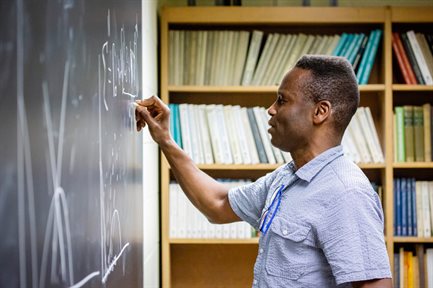 Physics professor at chalkboard